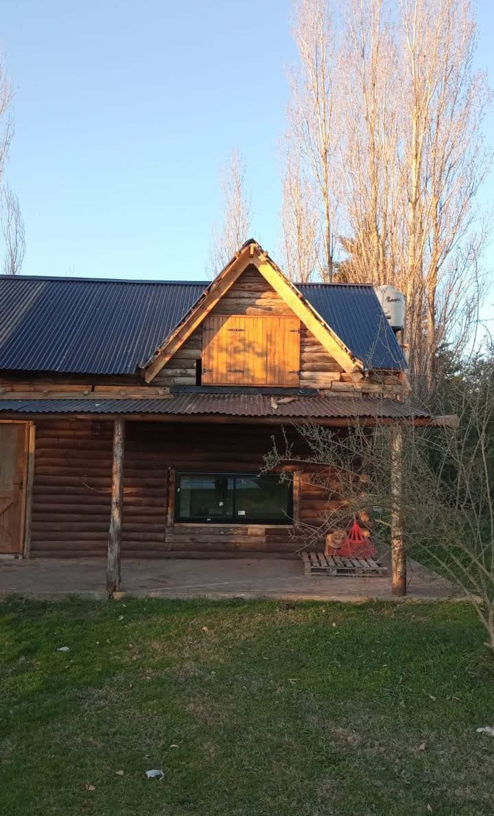 Cabaña de tronco de dos pisos con deck y terraza